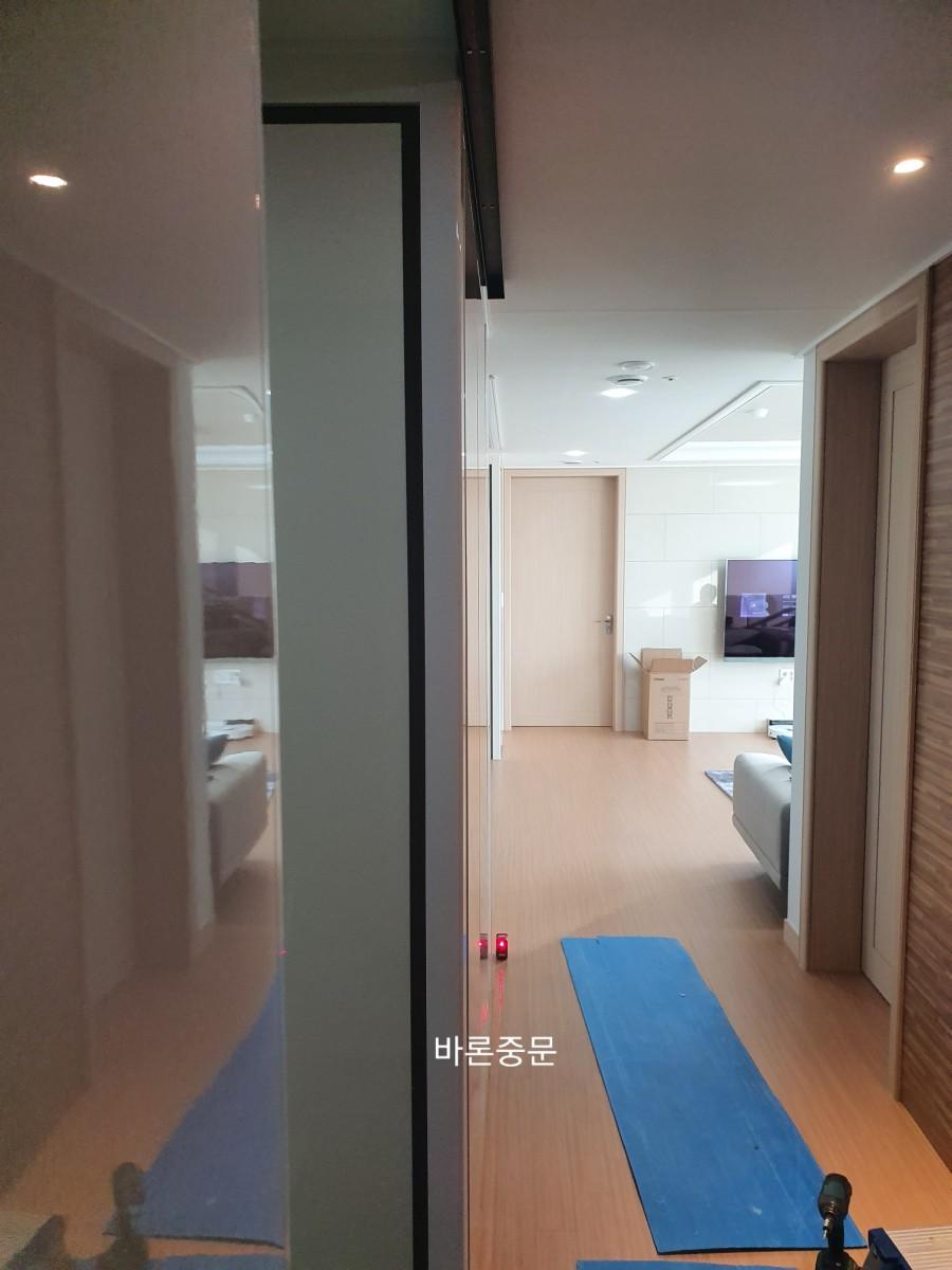 흰색 벽면과 나무 마루가 보이는 복도 시공 현장