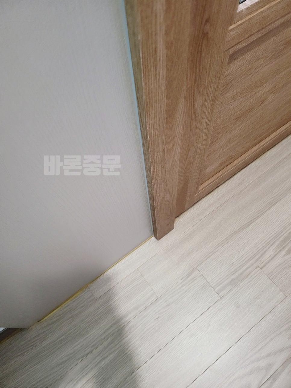 회색 벽면과 목재 도어가 맞닿는 틈새 부분