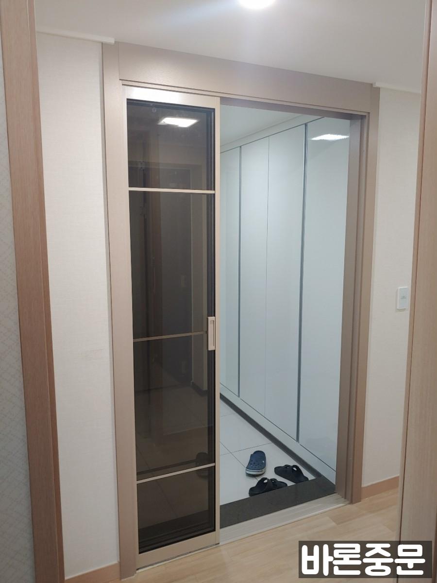 흰색 수납장 옆으로 배치된 슬라이딩 중문