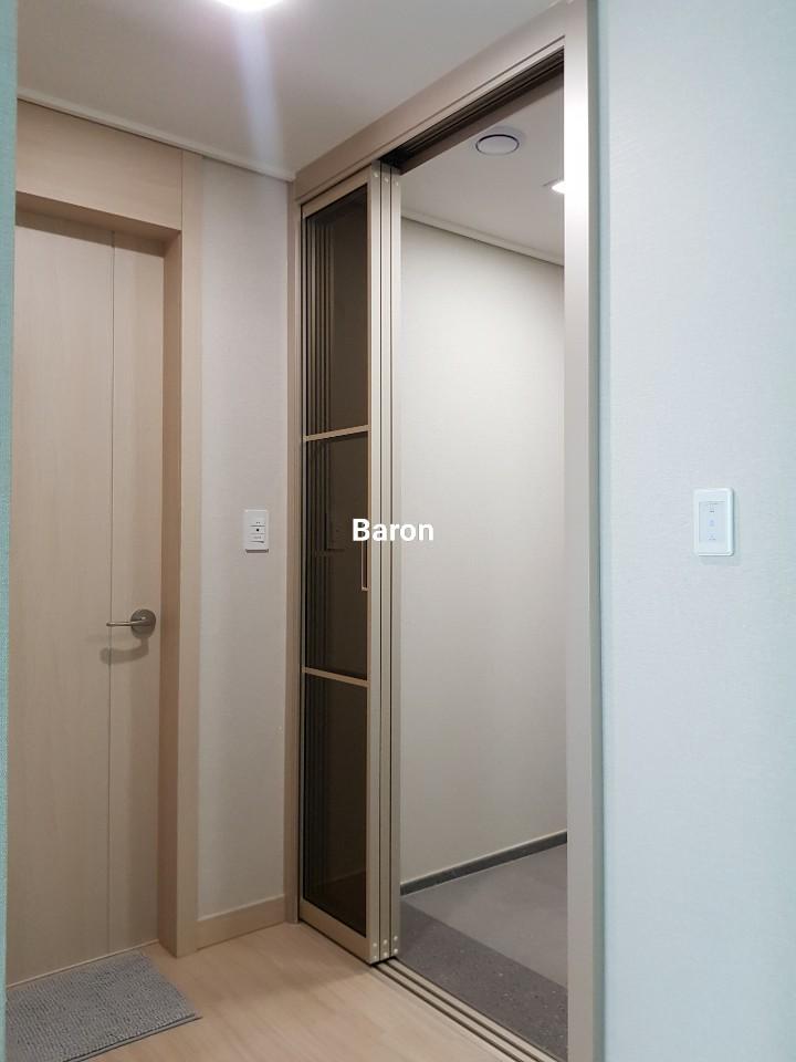 샴페인골드 프레임과 브론즈 유리가 적용된 현관 완성 모습