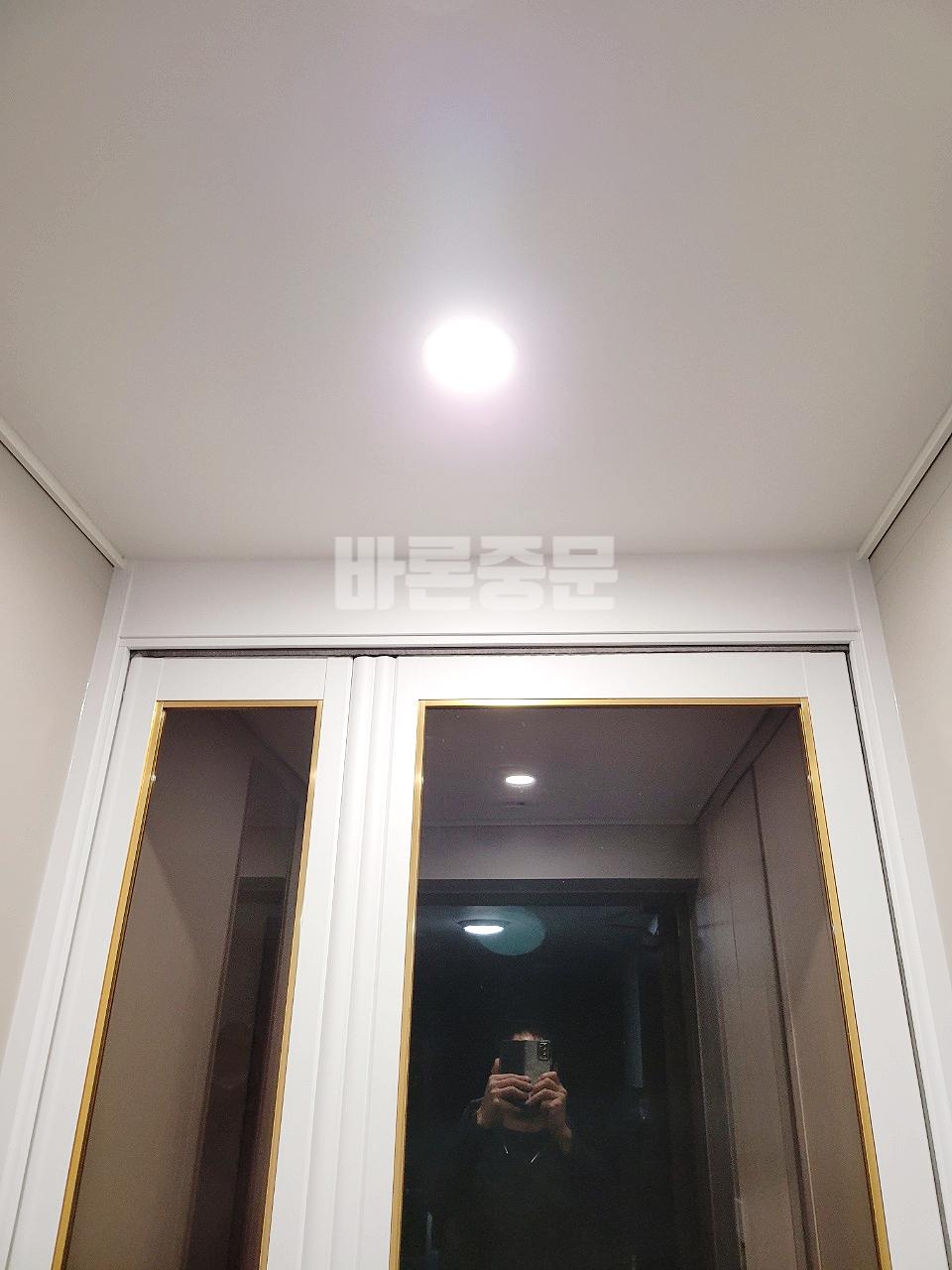 복도 조명과 어우러진 화이트 프레임 중문의 모습