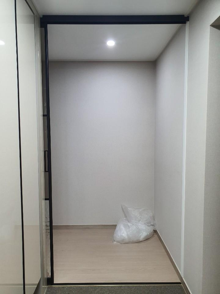 베이지색 톤의 복도에 설치된 블랙 슬라이딩 도어
