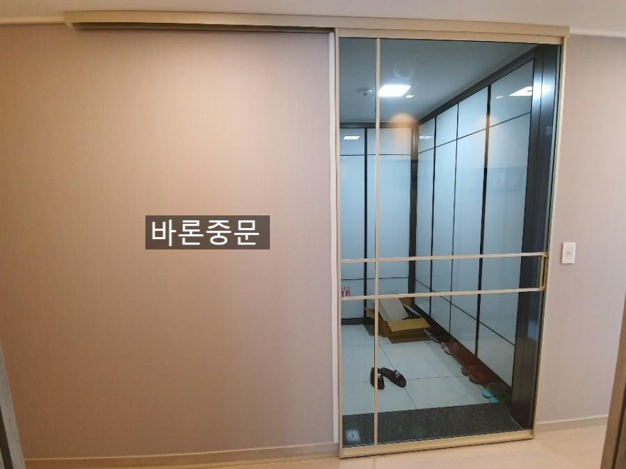 흰색 바닥과 벽면 사이에 고정된 중문 프레임
