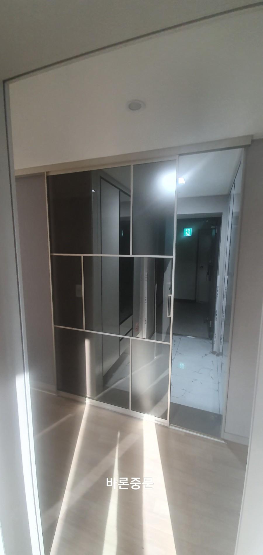 목재 마루 복도에 설치 중인 슬라이딩 도어