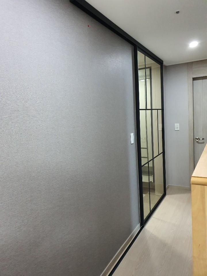 회색 벽면에 블랙 프레임 중문을 설치하는 과정