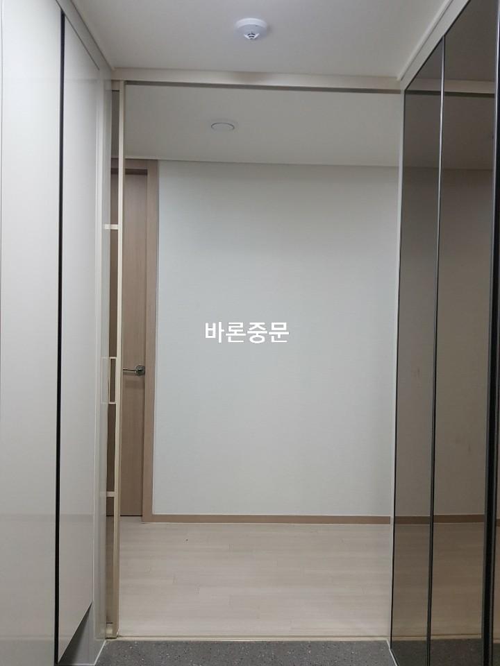베이지색 바닥재와 흰 벽면이 이어지는 복도 시공 구간