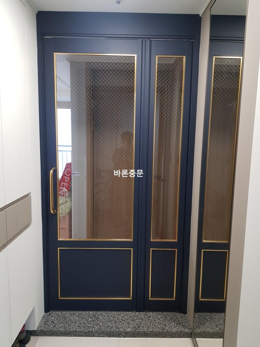 흰색 수납장과 골드 손잡이가 돋보이는 듀얼 중문
