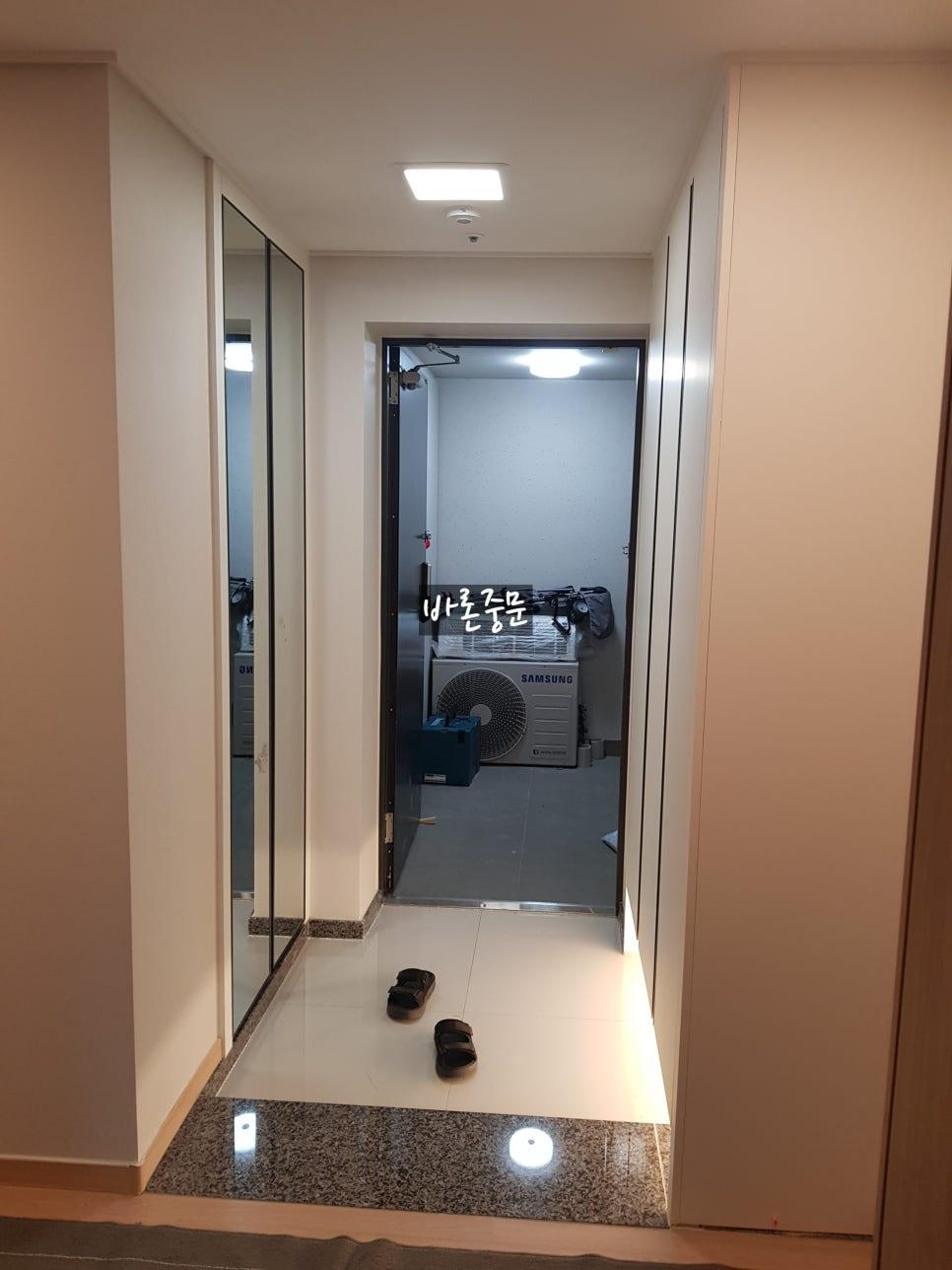중문 설치를 앞둔 흰색 타일의 현관 입구