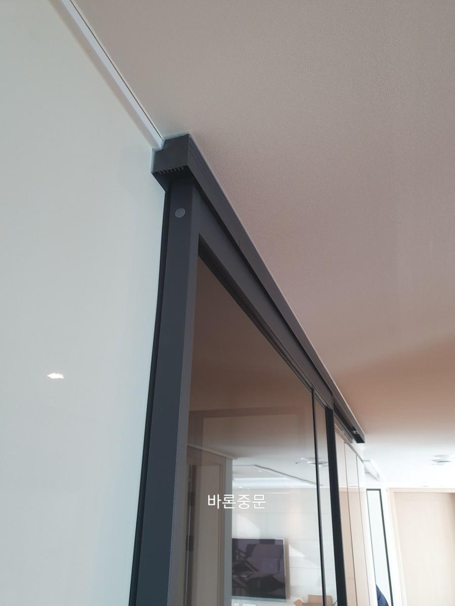 베이지색 천장과 흰색 벽 사이에 설치된 검은색 프레임 상부