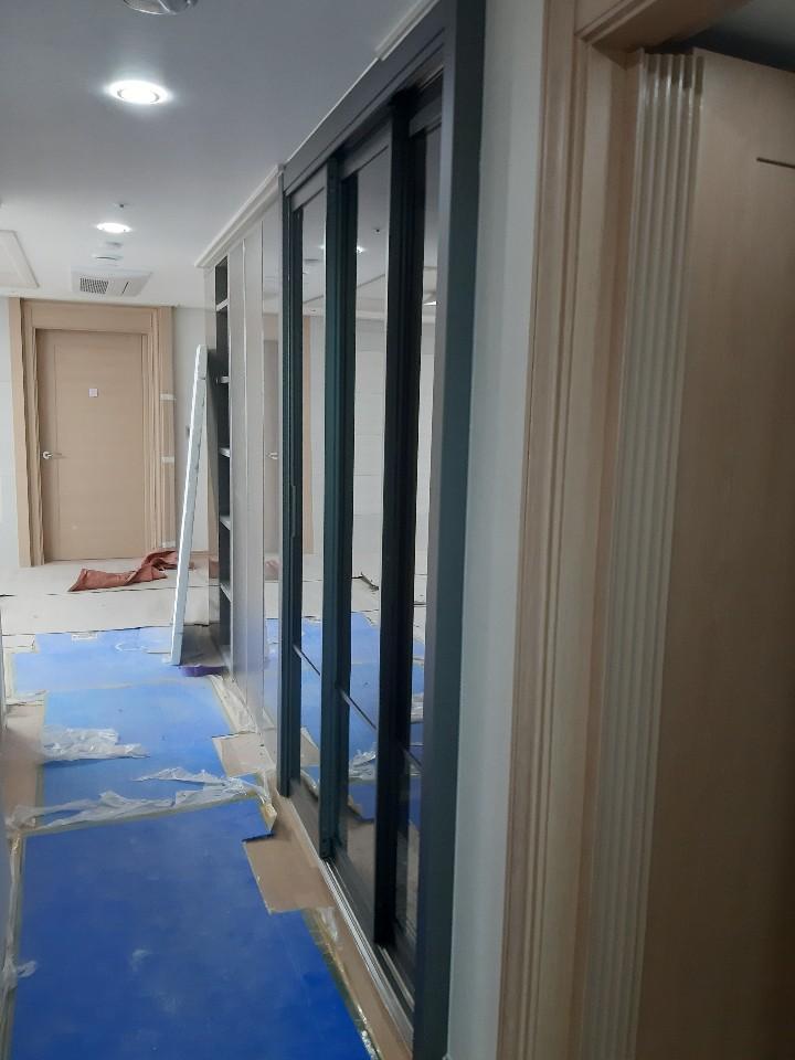 유리문과 수납장이 나란히 배치된 복도
