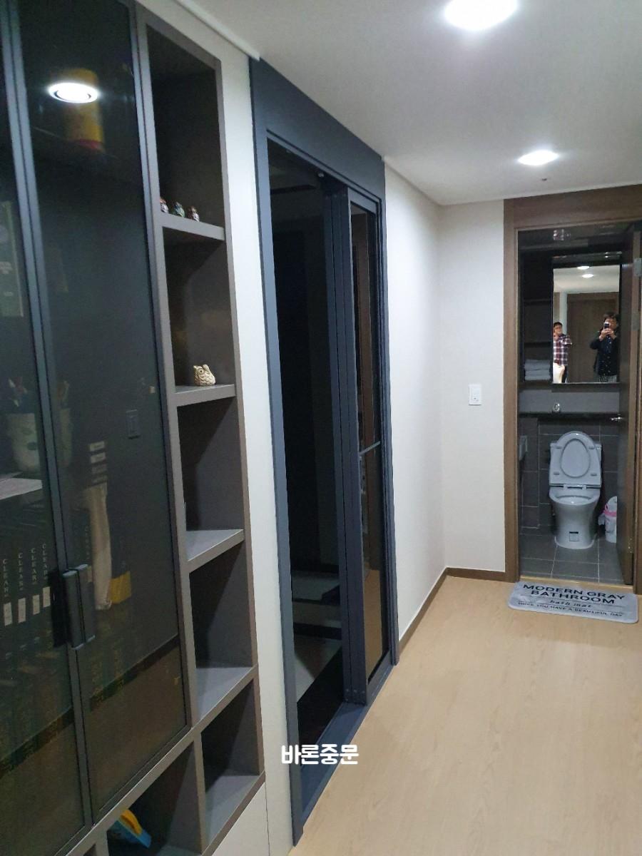회색 유리 도어와 어두운 우드톤 붙박이장의 조화