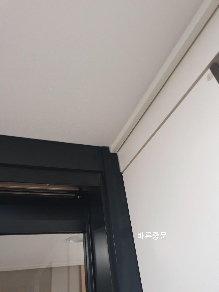 천장과 벽 접합부에 밀착 시공된 도어 프레임 상단