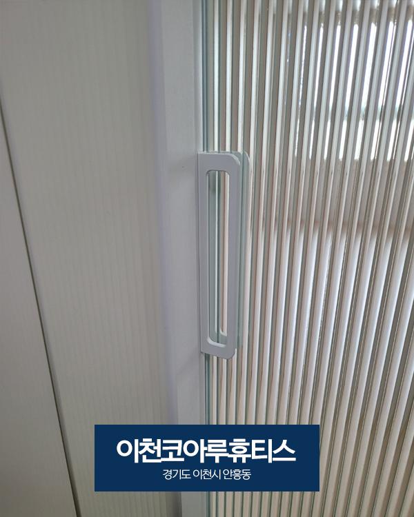 도어 유리 패널과 문짝을 연결하는 흰색 플라스틱 핸들