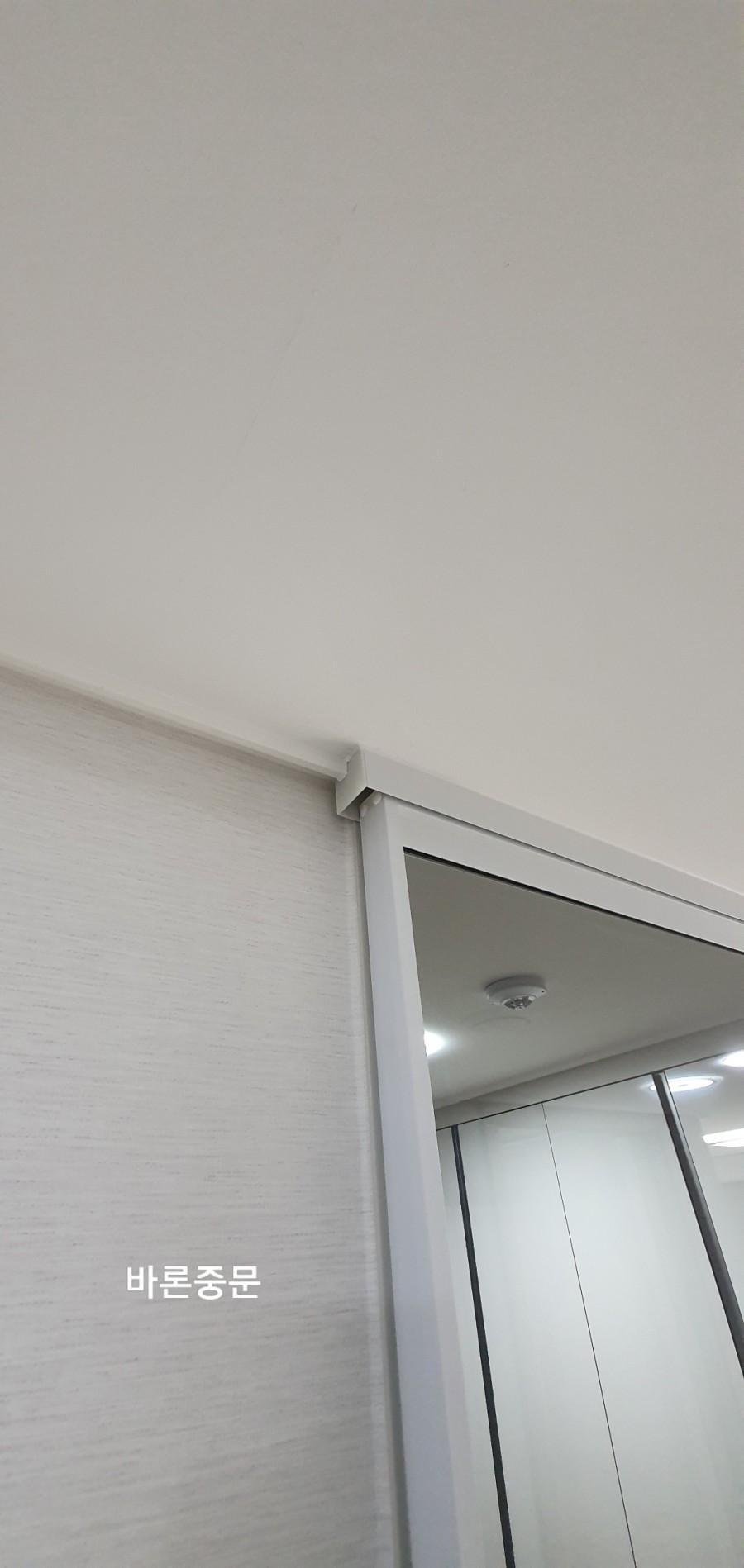 천장과 벽면 연결부에 밀착된 도어 프레임 마감