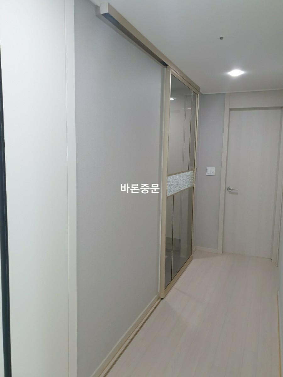 회색 벽면과 슬라이딩 도어가 어우러진 복도