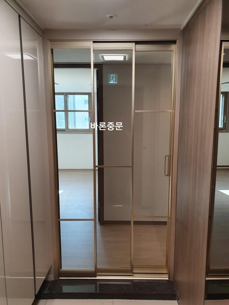 검은색 타일 바닥 위에 설치된 금속 프레임 중문