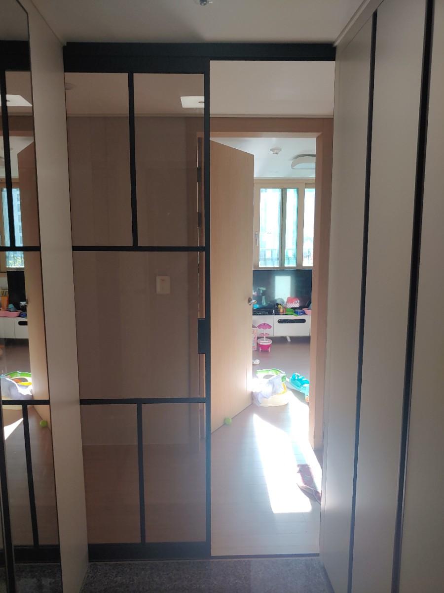 검은색 프레임 도어 너머로 보이는 타일 바닥의 내부