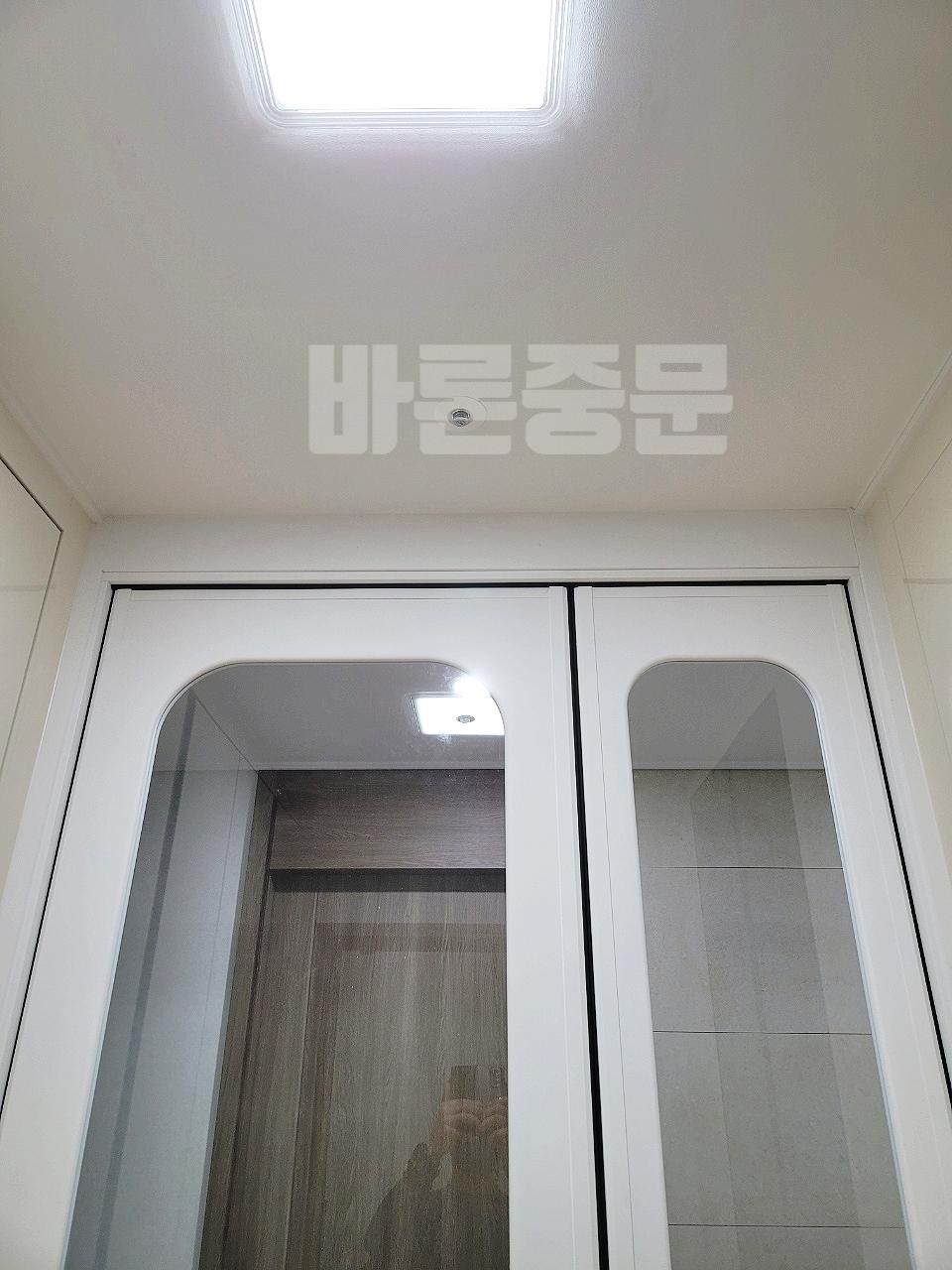 화이트 슬라이딩 도어가 설치된 정돈된 드레스룸