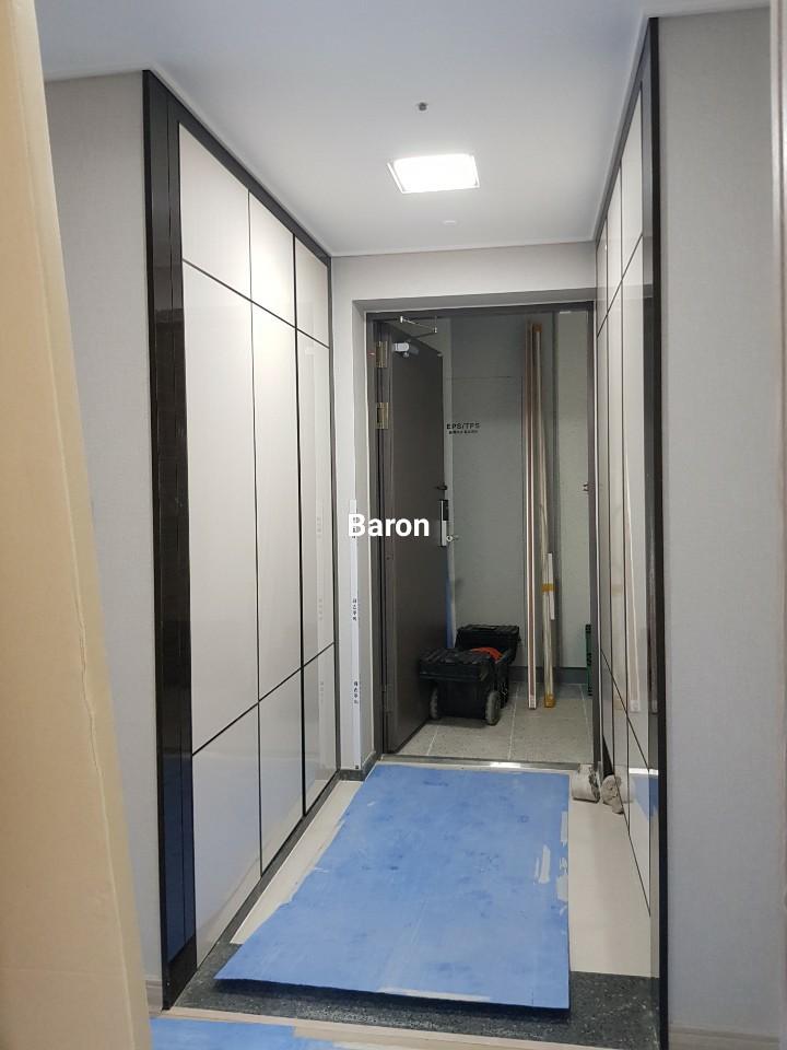 파란색 보호 매트가 깔린 복도와 수납장 설치 상태