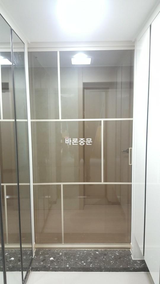 손잡이가 부착된 투명 유리문과 바닥 마감재