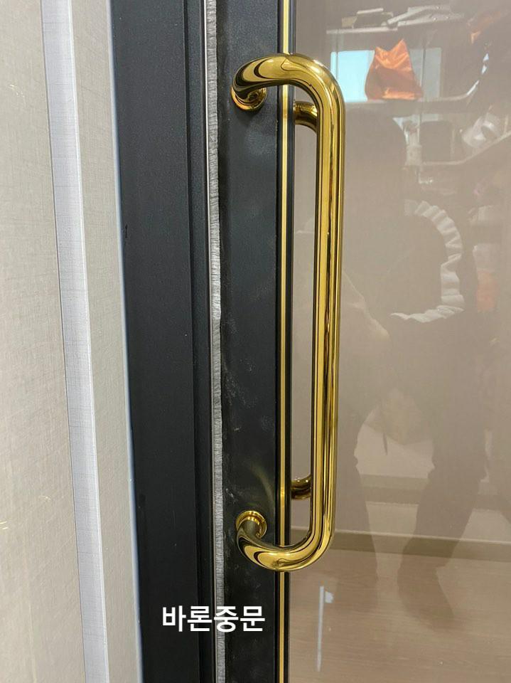 블랙 도어에 설치된 골드 라운드 손잡이 근접샷