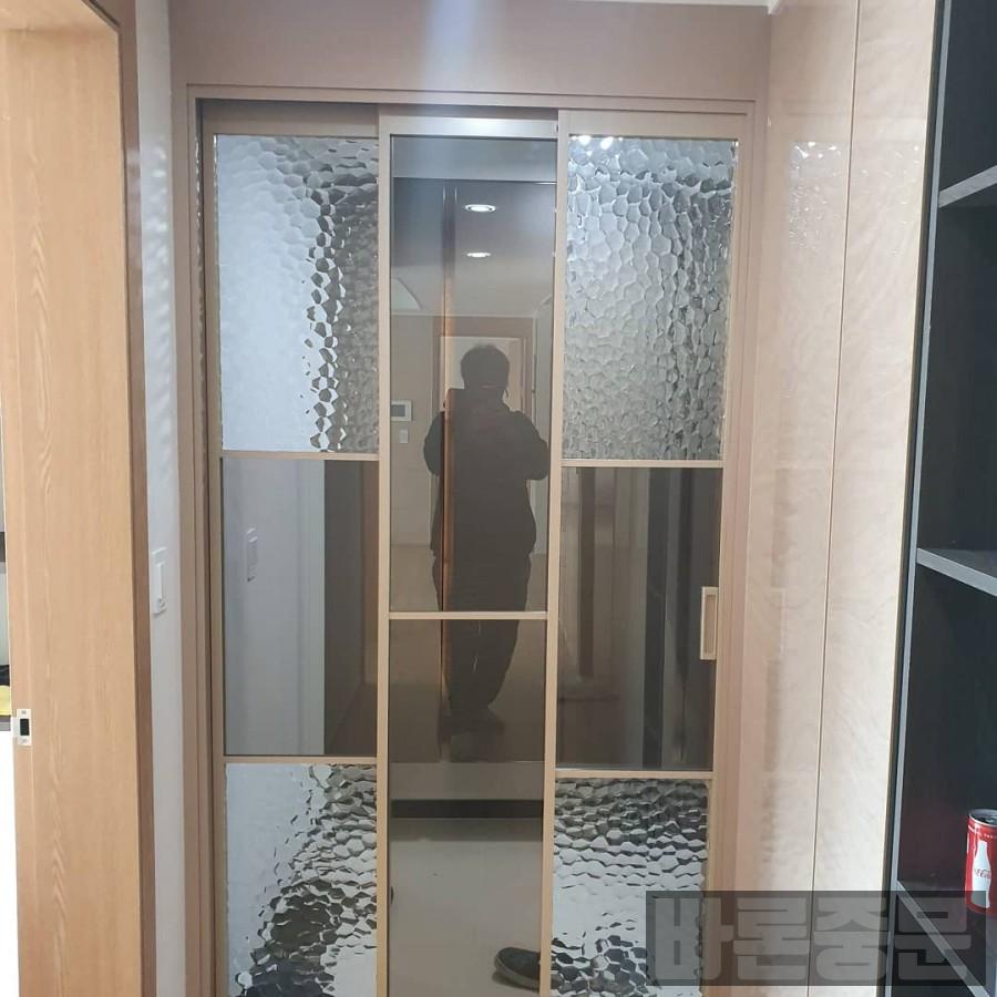 허수아비 무늬 유리 패널이 적용된 슬라이딩 도어와 주변 수납장