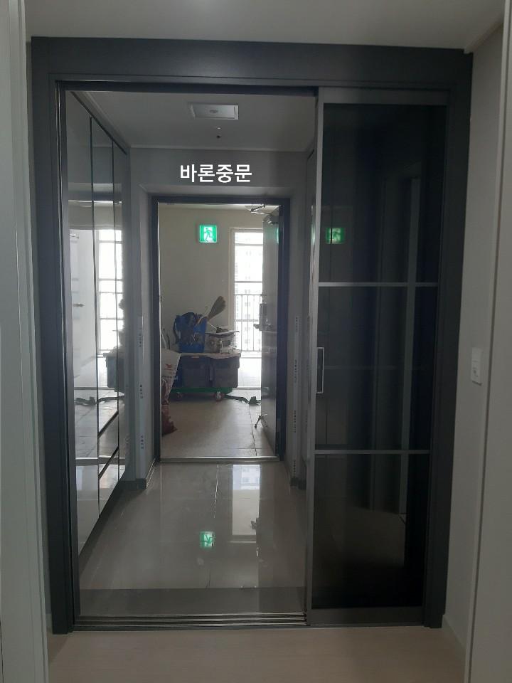 타일 바닥 위에 설치된 슬라이딩 도어와 유리 패널
