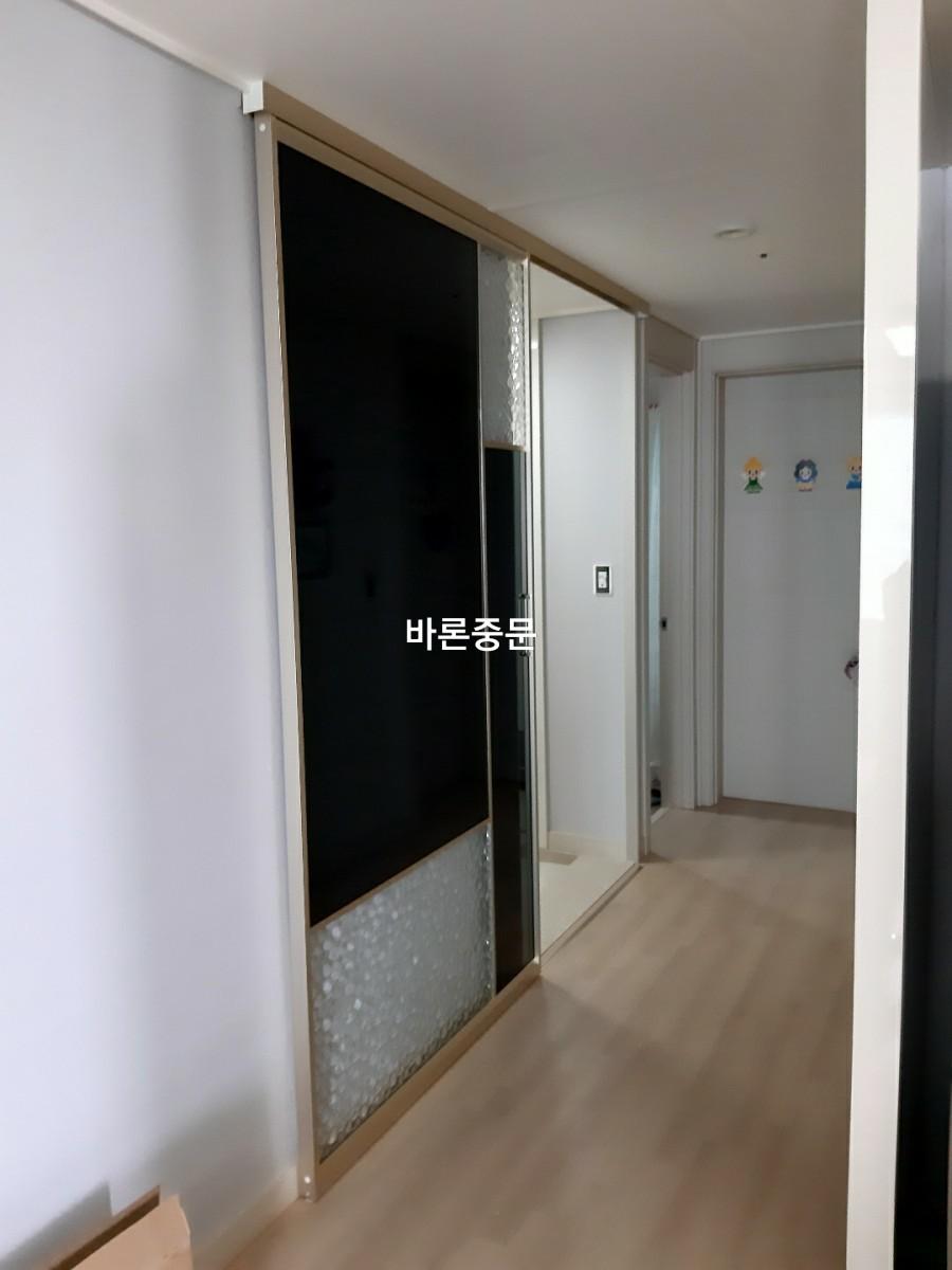 흰색 벽면과 대비되는 유리 패널 슬라이딩 문