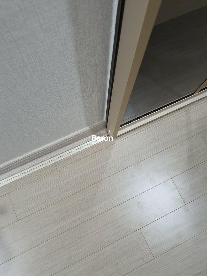 유리 문 하단 프레임과 바닥재의 접합 부분