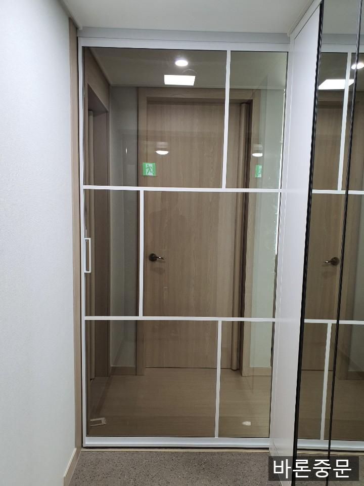 화이트 프레임과 유리 패널의 슬라이딩 도어