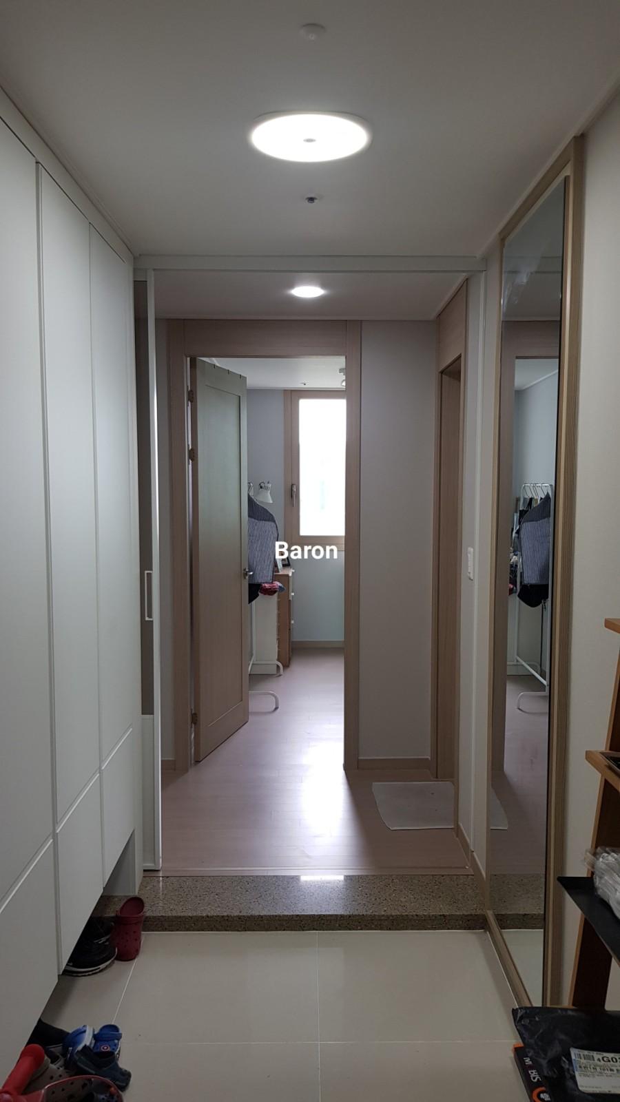 문이 열린 상태로 연결된 복도와 수납장