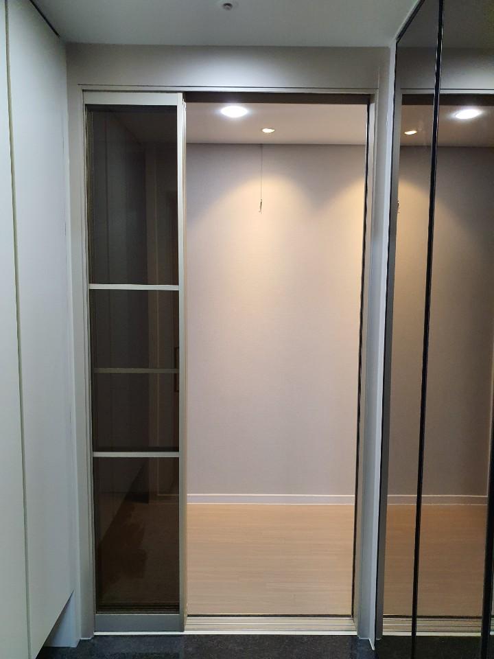 베이지색 벽지와 목재 패널이 조화로운 공간