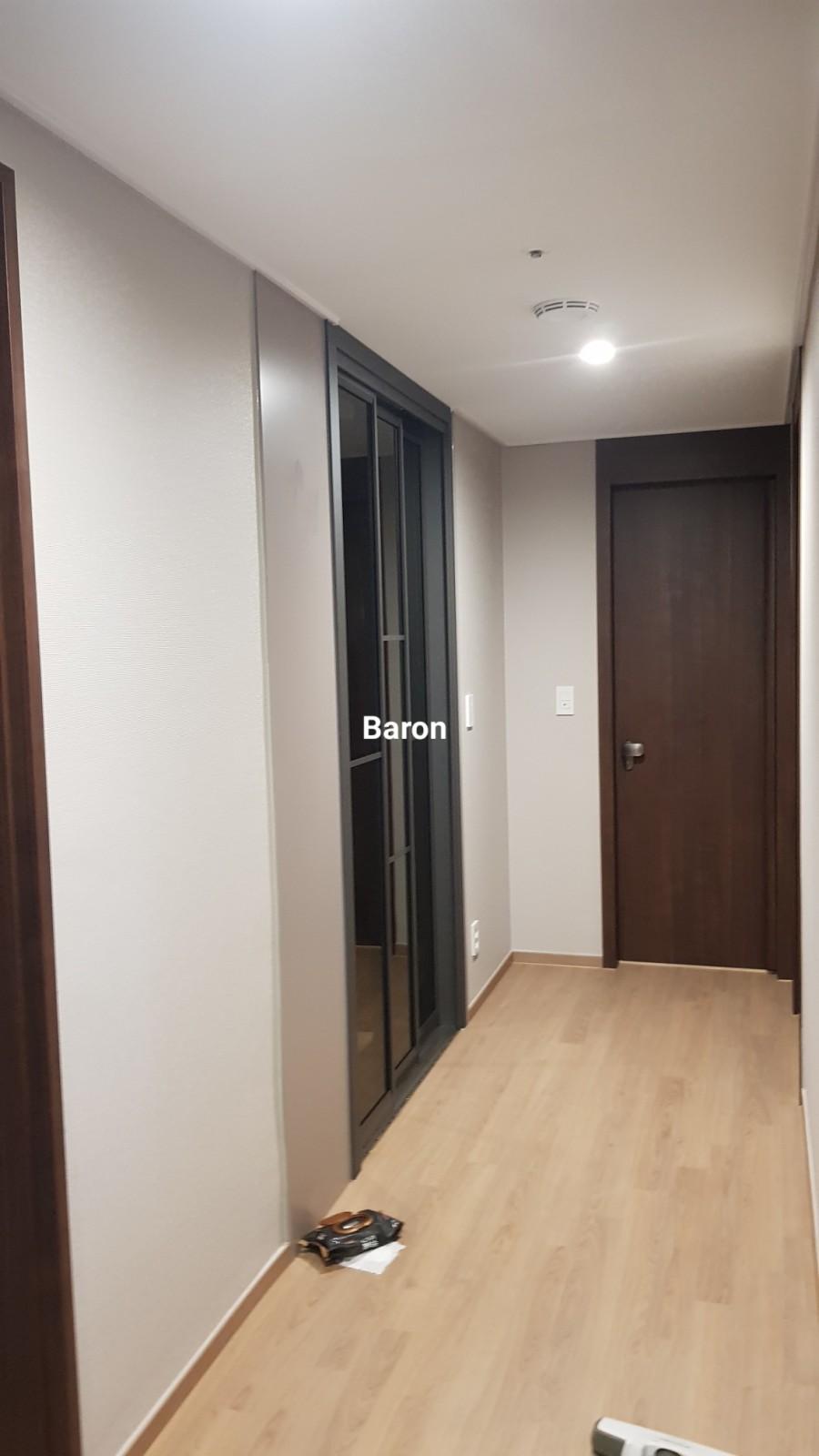 베이지색 벽지와 대비되는 검은 테두리 도어