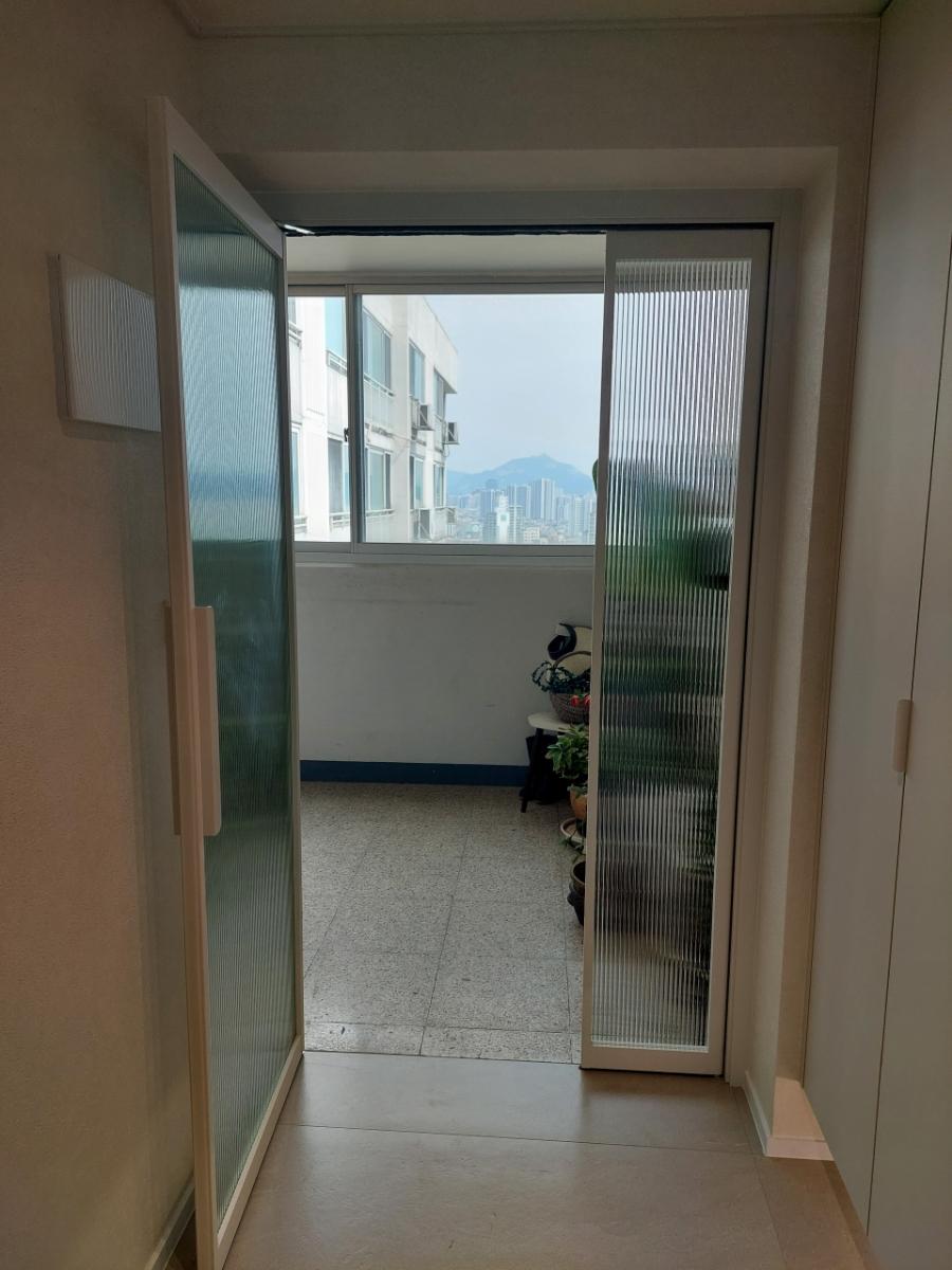 석재 타일과 화이트 벽면이 깔끔한 발코니 공간