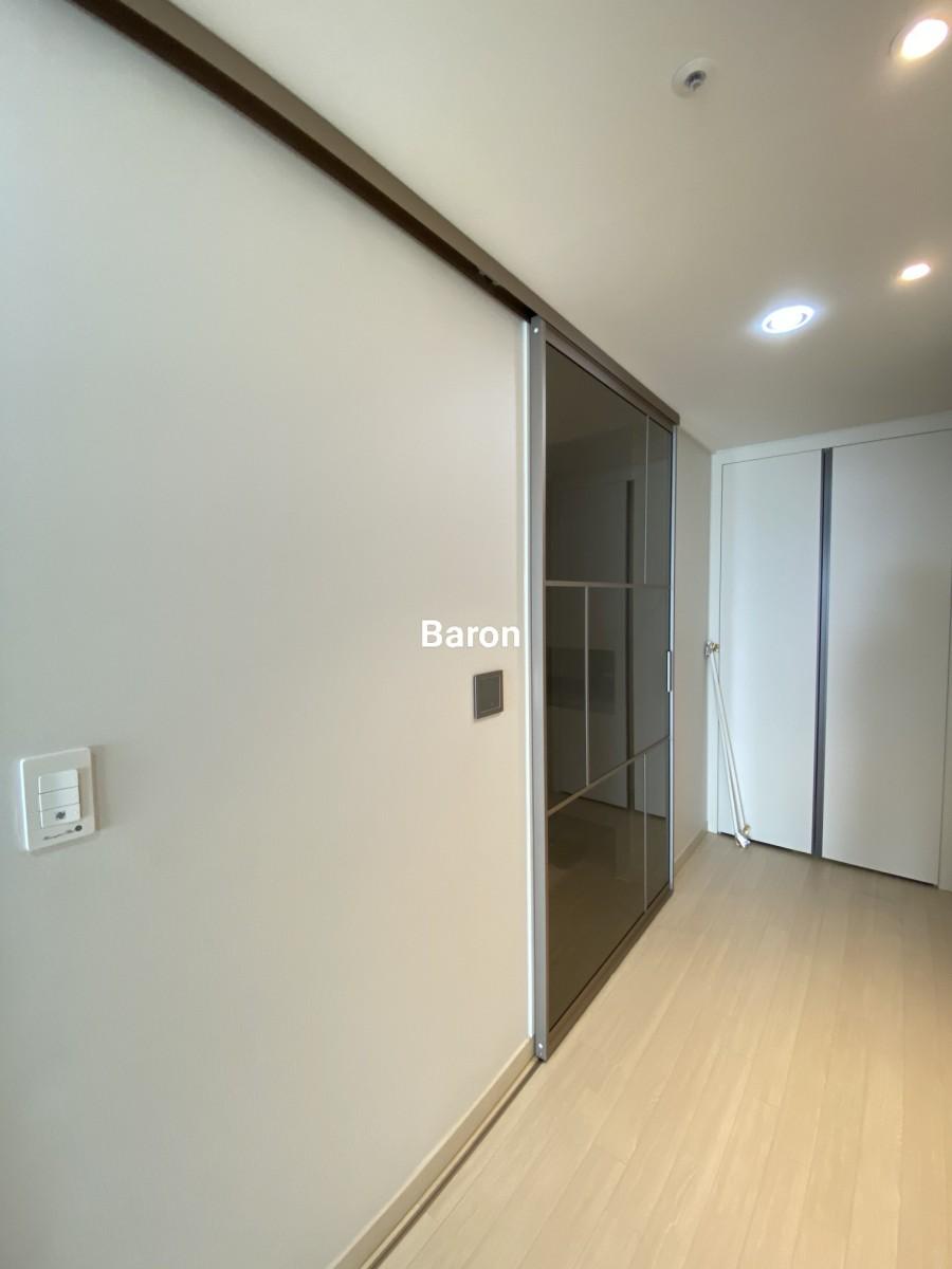 베이지색 벽면과 목재 마루 위 설치 중인 도어