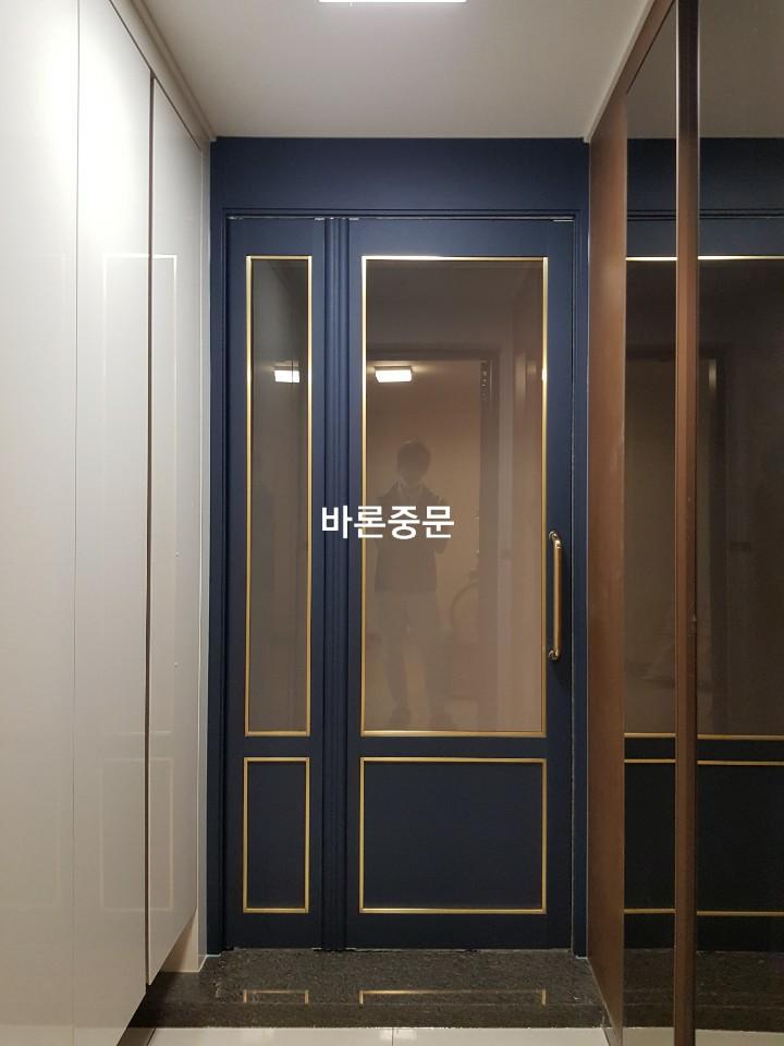 수납장 사이로 설치된 도어와 검은색 현관 바닥재의 모습