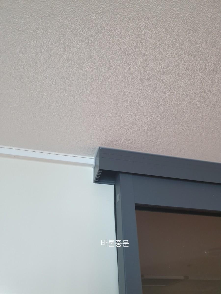 문 상단 프레임과 벽면의 접합부 근접 모습