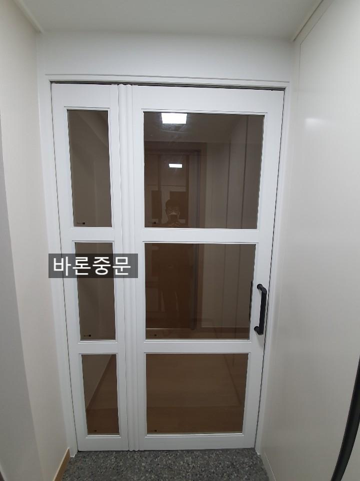 회색 타일 바닥 위에 설치된 화이트 도어