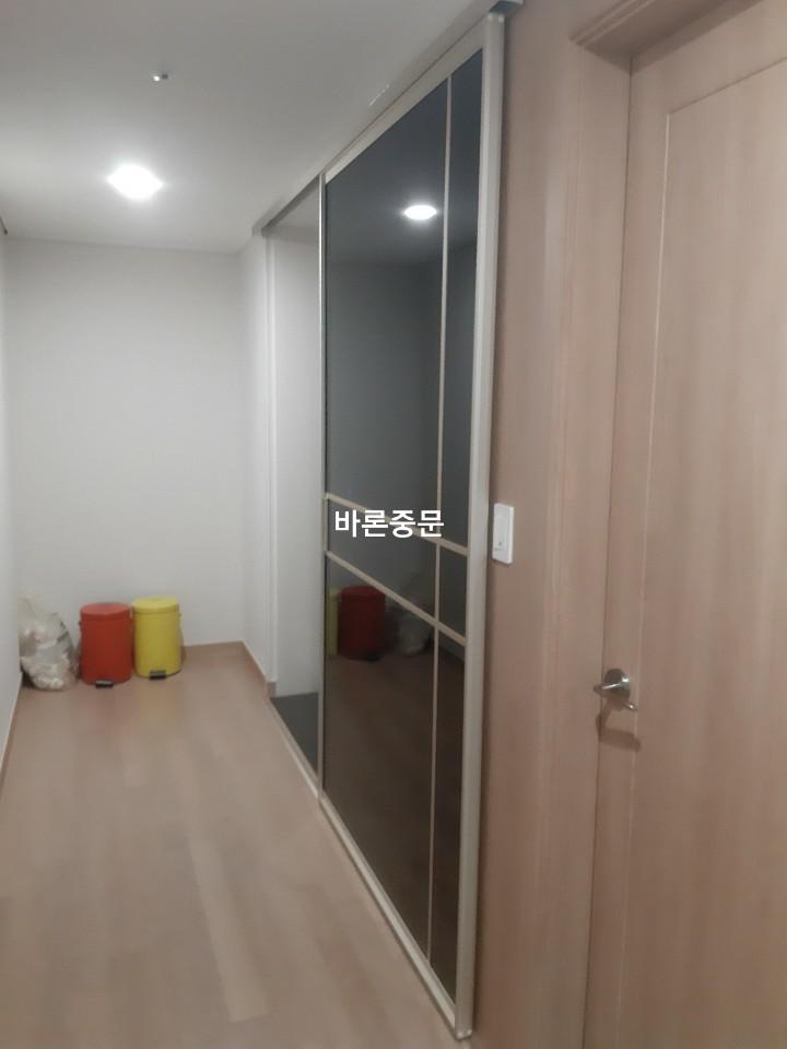 흰색 벽면과 나무 마루가 깔린 복도 시공 현장
