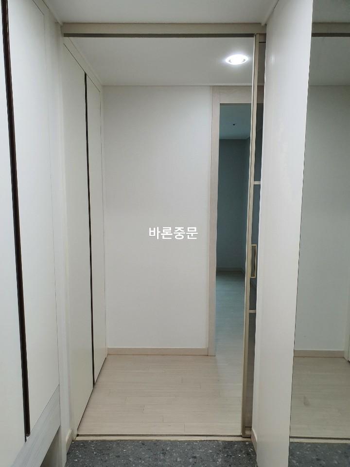 밝은 바닥재와 흰 벽면이 보이는 복도 공간