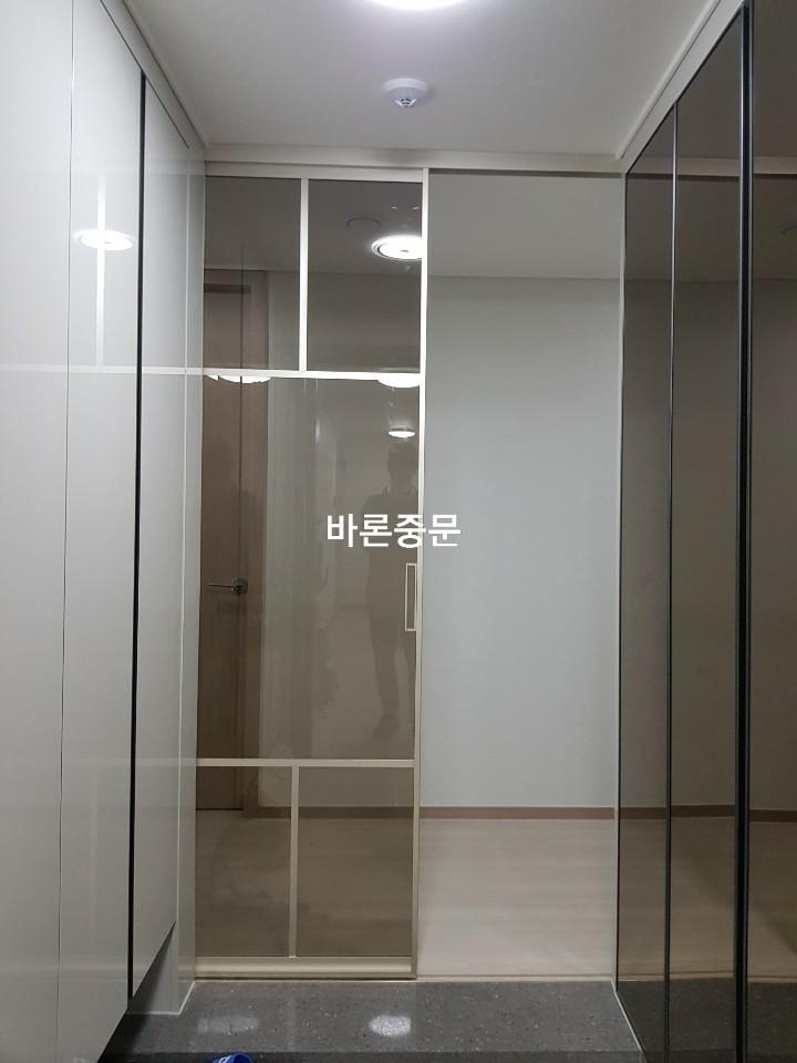 어두운 타일 바닥 위에 설치된 투명 유리 패널 문
