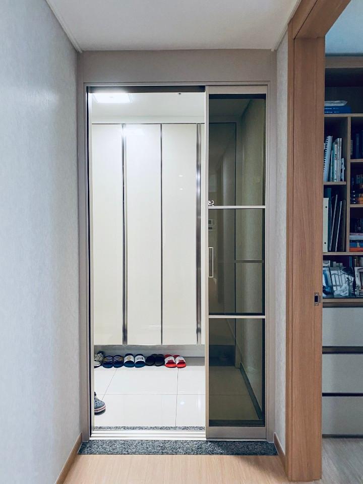 중문 너머로 보이는 흰색 수납장과 서재 공간