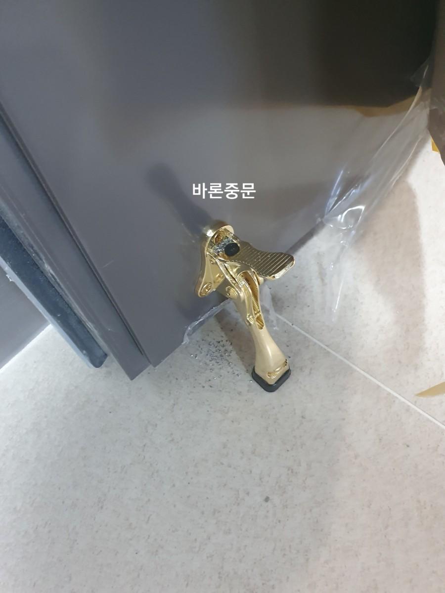 금색 도어 핸들이 부착된 문체와 타일 바닥