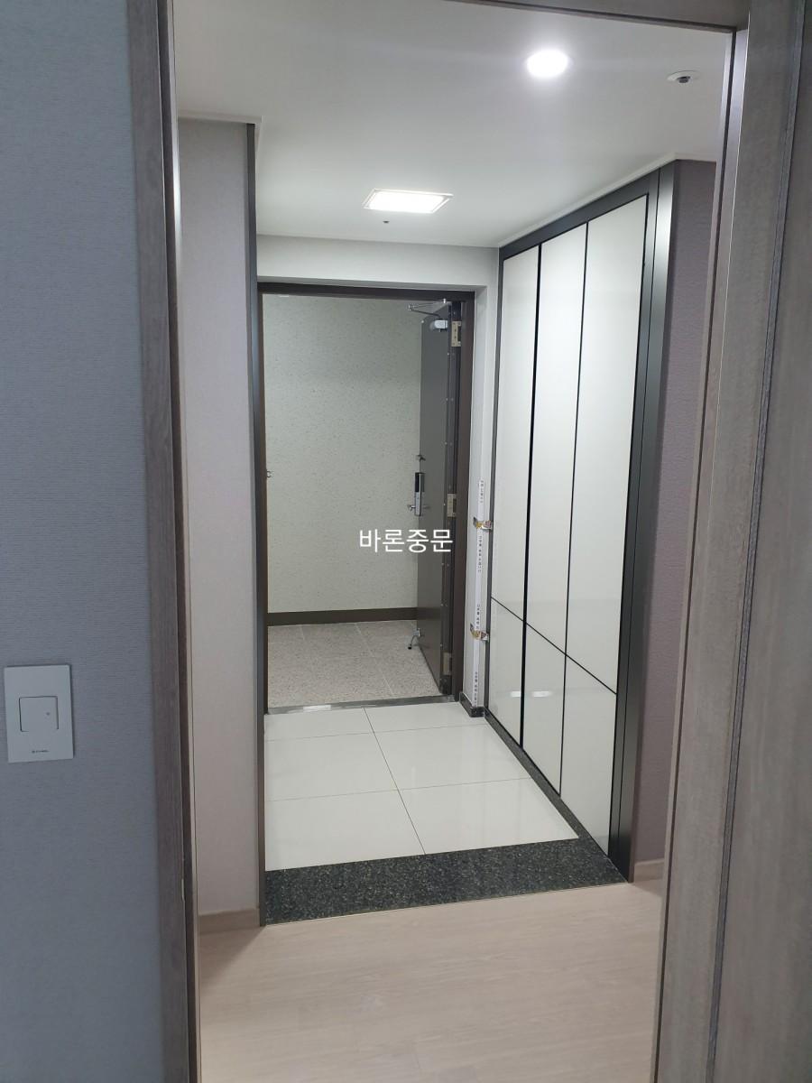 화이트 프레임과 브론즈 유리가 조화를 이룬 현관 중문