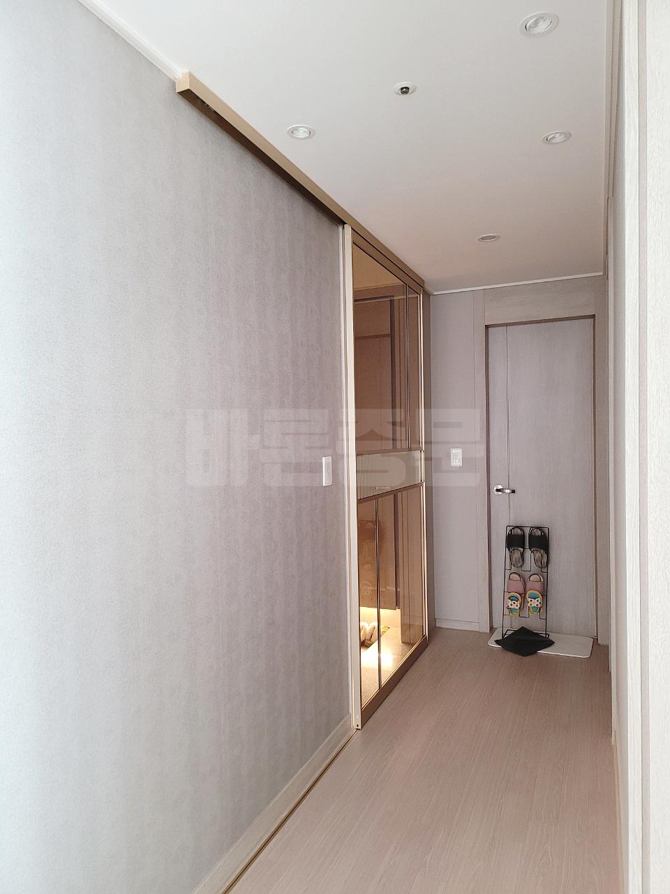 회색 벽지와 목재 바닥재가 깔린 복도의 전경