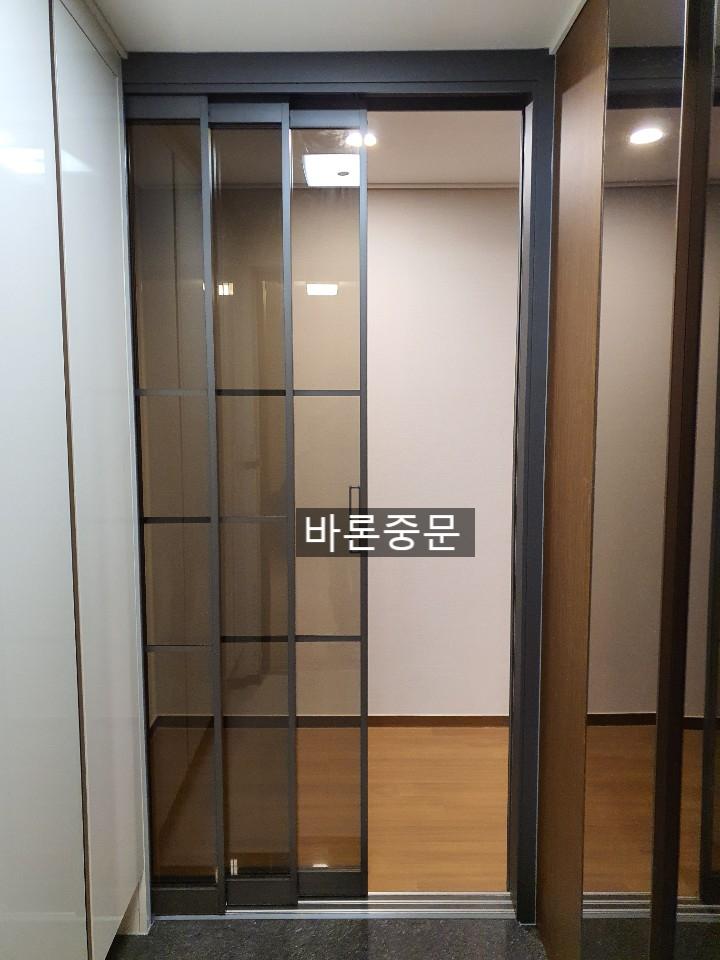 검은색 프레임과 유리 패널이 설치된 복도 전경