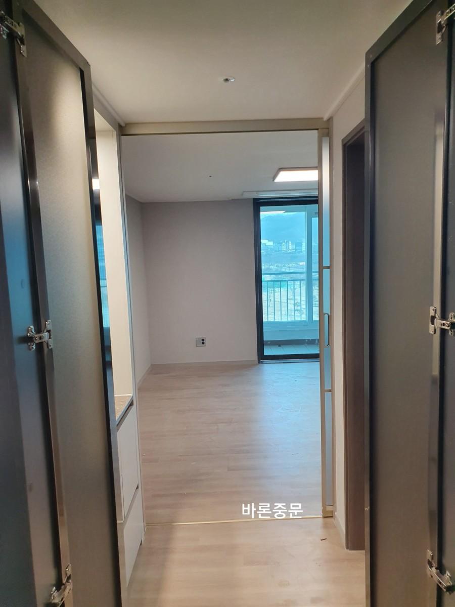 문이 열린 상태의 복도와 목재 마루 바닥