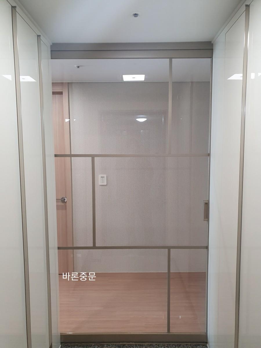 유리 패널과 손잡이가 보이는 도어의 모습