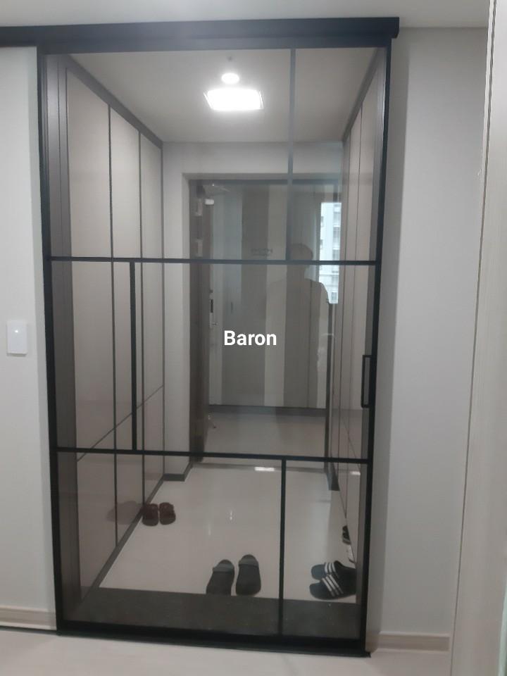 블랙 프레임의 슬라이딩 유리문이 설치된 현관