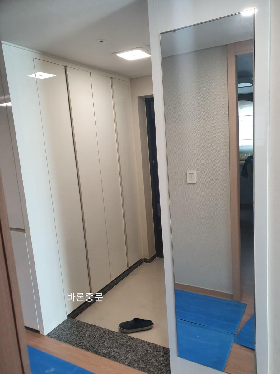 흰색 수납장이 있는 현관 공간의 모습